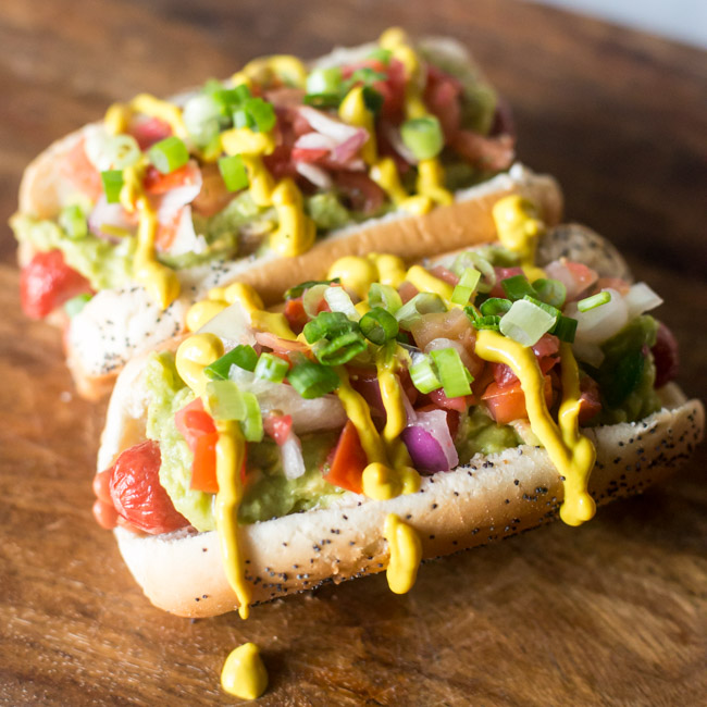 These Easy Sonoran Hot Dogs add a little Southwestern flair to your frank with pinto beans, guacamole, pico de gallo and more!